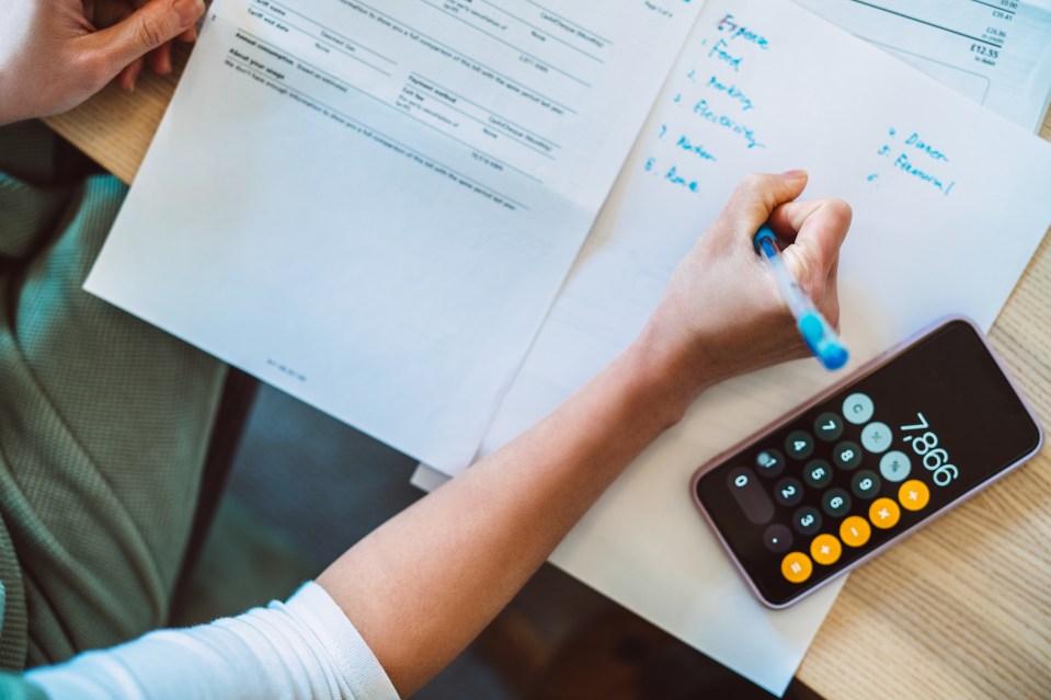 a person is using a calculator and writing on a piece of paper