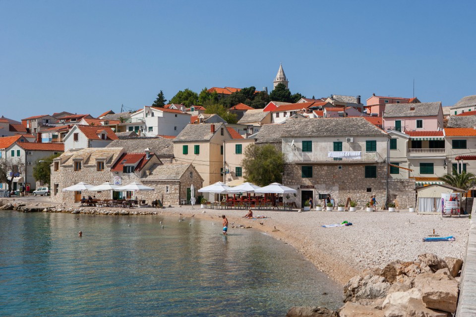 a beach in front of a small town with a sign that says ' a ' on it