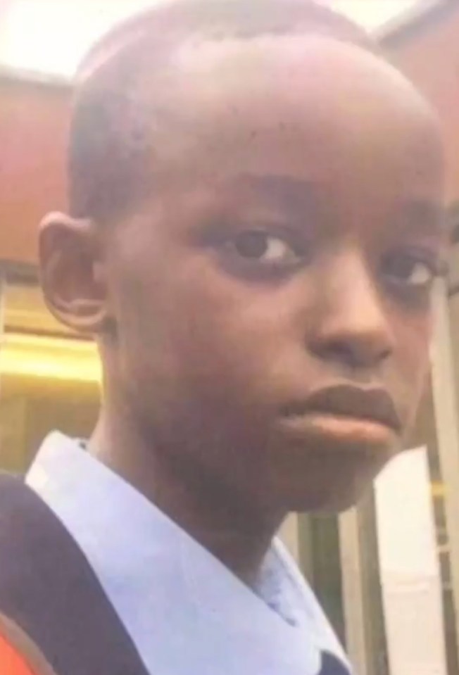 a young boy in a blue shirt and tie is making a funny face .