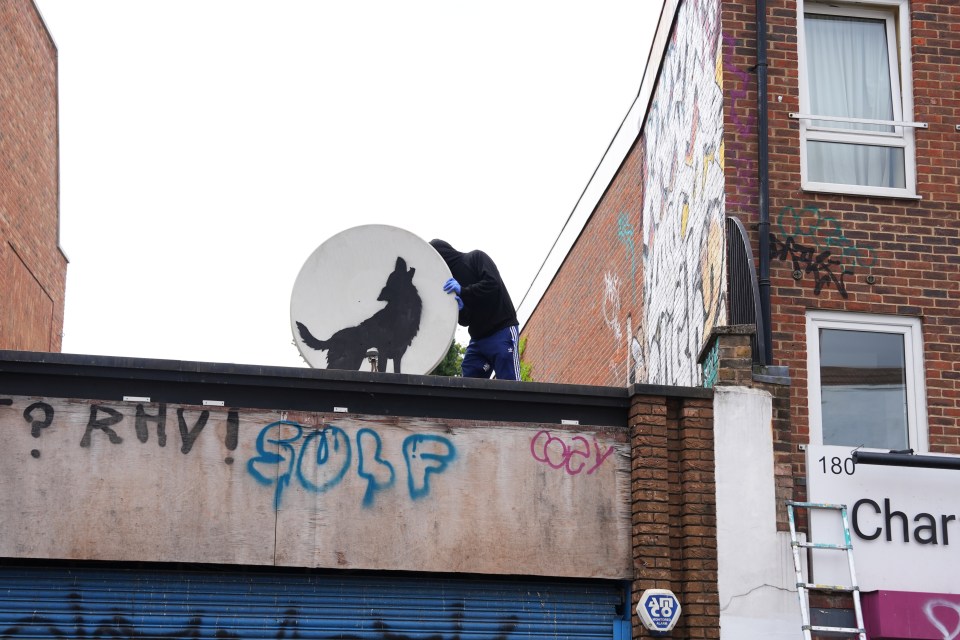 a person standing on top of a building with the word golf spray painted on it