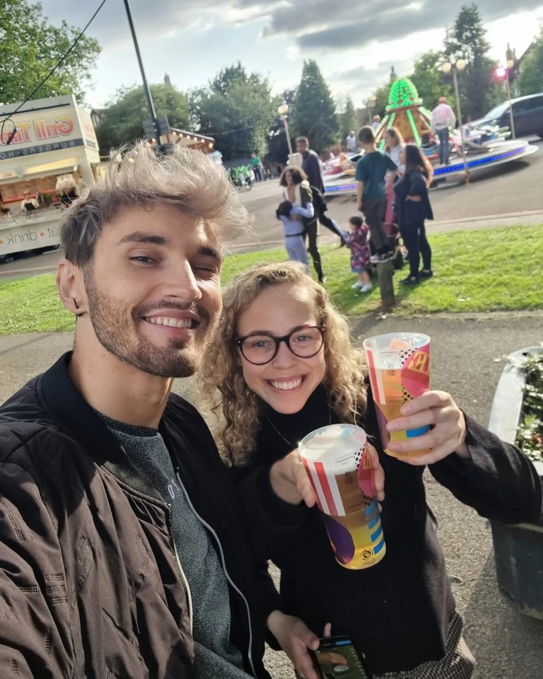 a man and a woman are holding cups in front of a food truck that says ' chilli ' on it