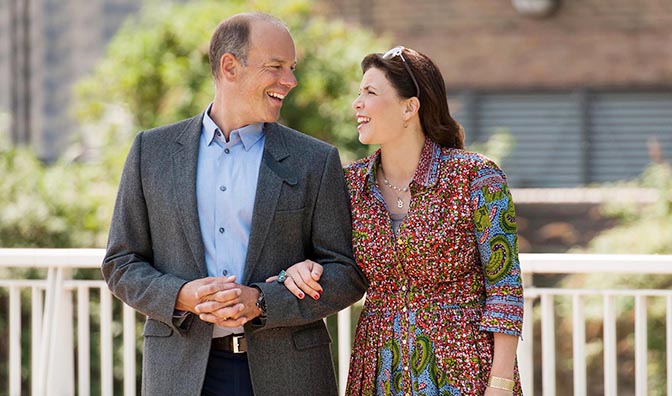 a man and a woman are standing next to each other and smiling