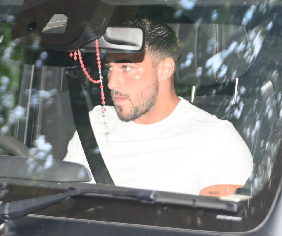 a man wearing a rosary is sitting in a car