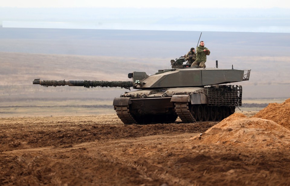 a man stands on top of a tank in a field