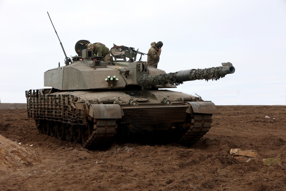 a military tank is driving through a muddy field