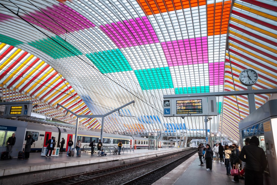 a train station with a colorful ceiling and a sign that says 1