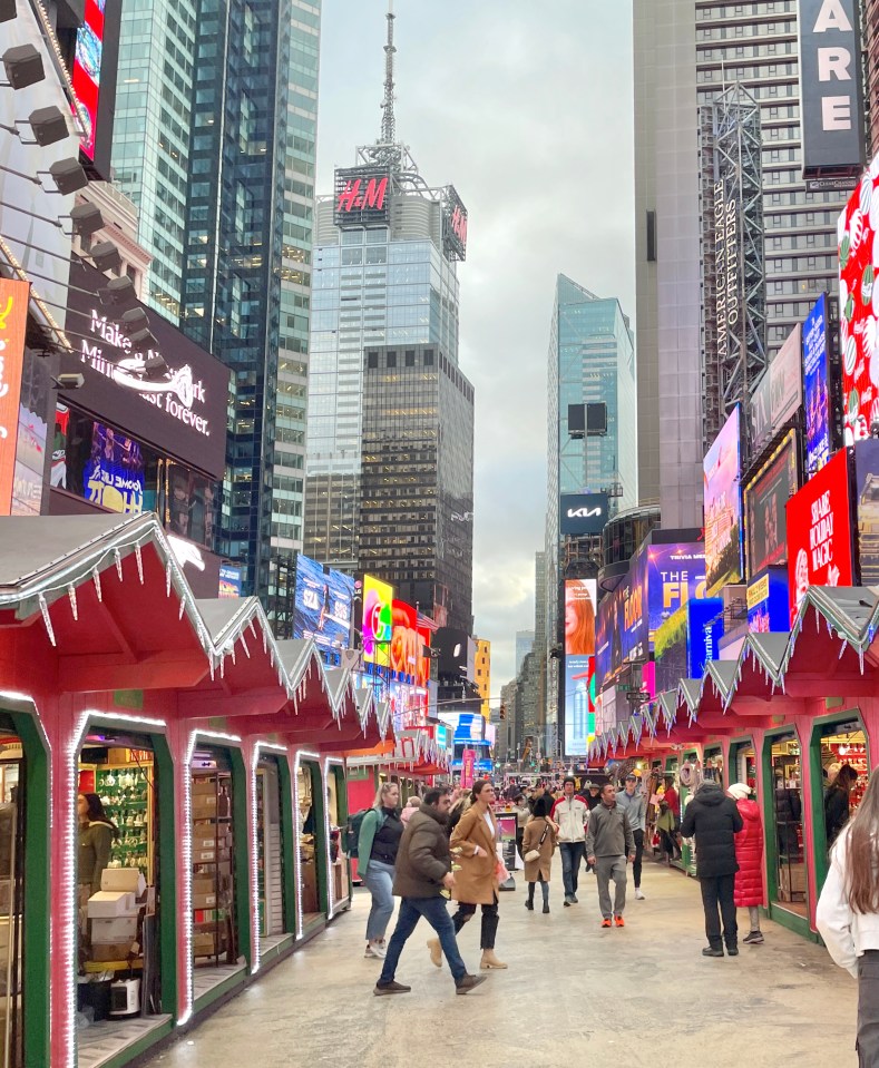 a busy city street with a h & m building in the background