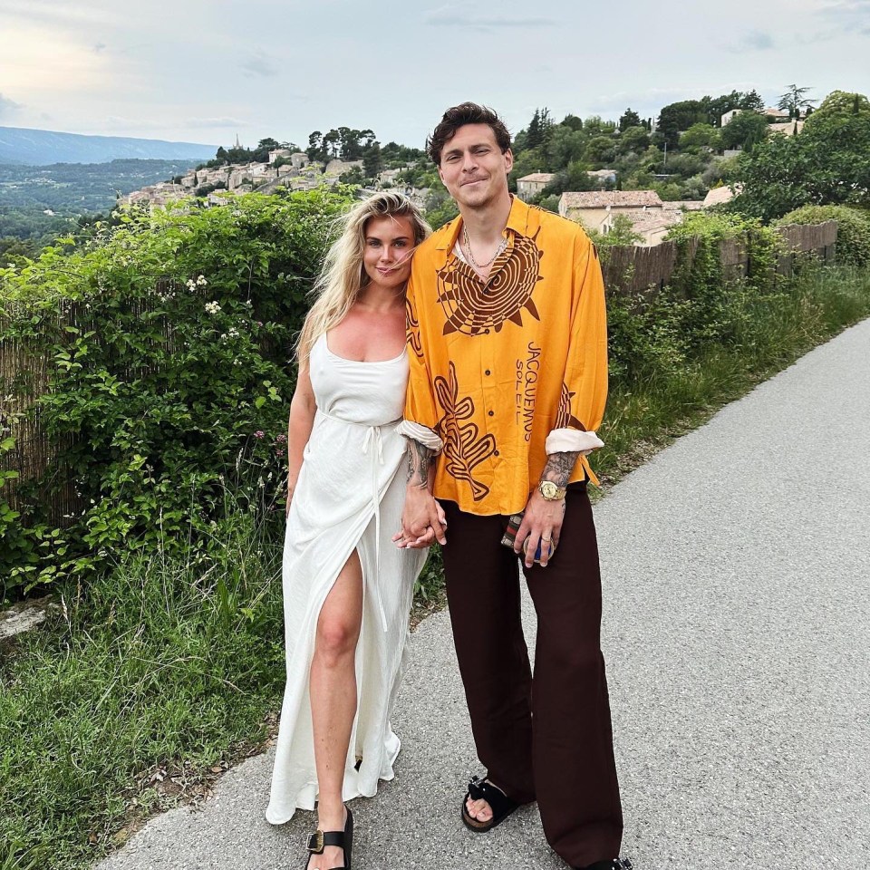 a man in a yellow shirt that says jacquemus stands next to a woman in a white dress