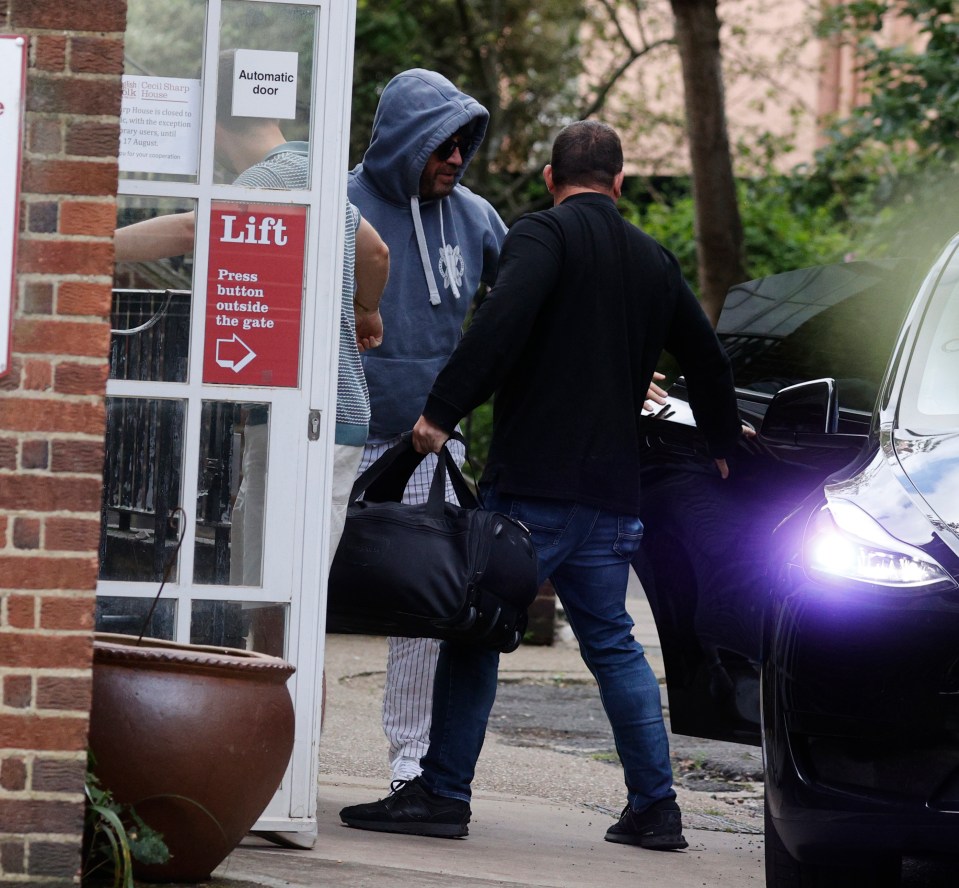 a man carrying a bag is entering an automatic door