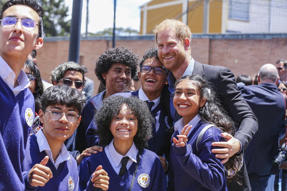 a group of young people posing for a picture with a man in a suit