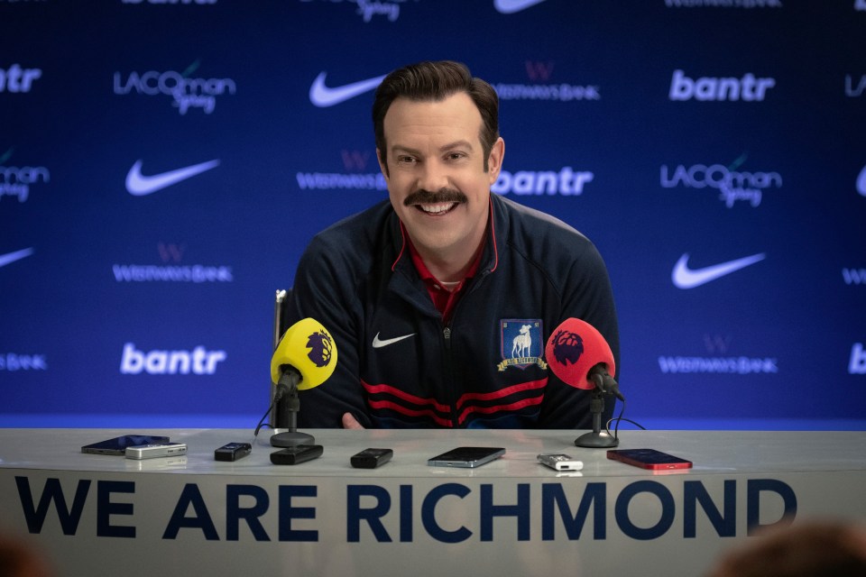 a man sitting at a table with a sign that says we are richmond