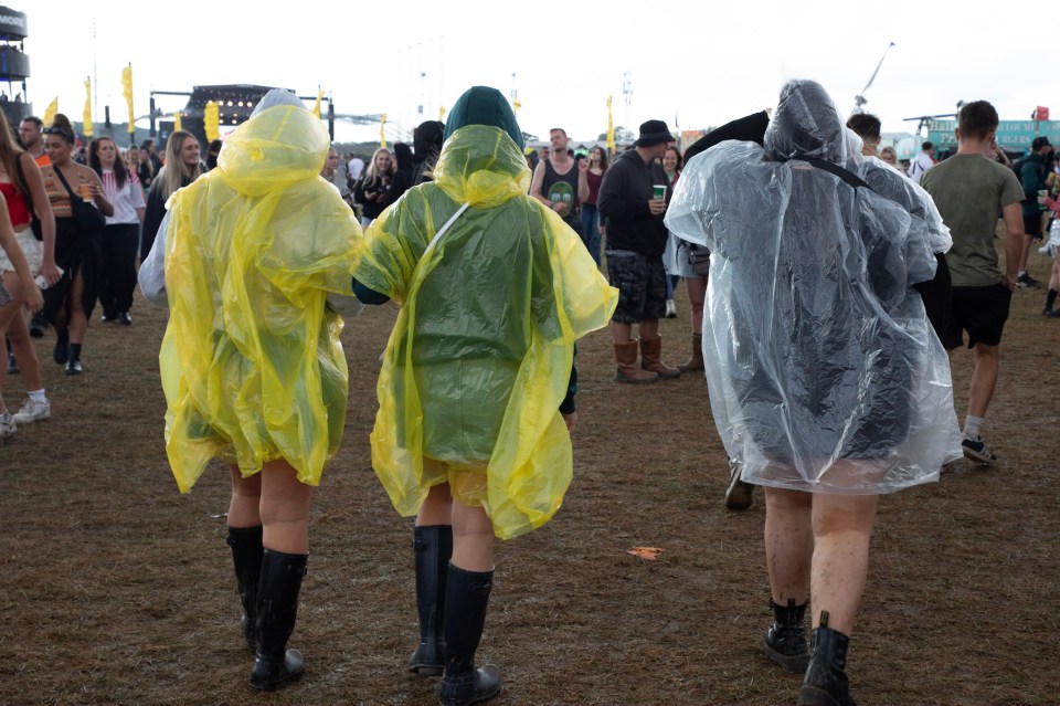 three people wearing yellow raincoats stand in a crowd