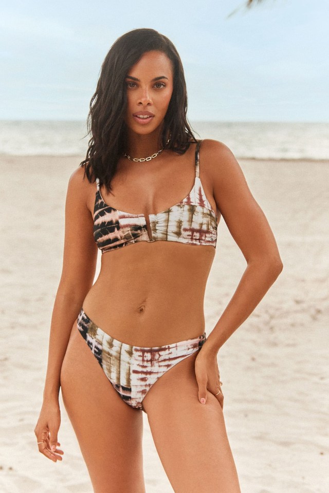 a woman in a bikini is standing on a beach