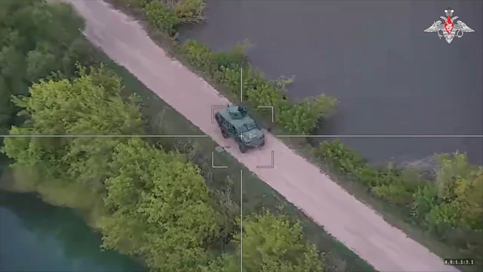 an aerial view of a military vehicle on a dirt road