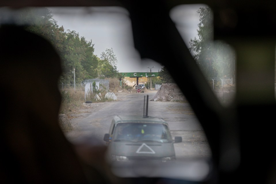 The damaged Russian border crossing post, with a Cyrillic sign reading ‘Russia’ and a painted Ukrainian sign reading ‘no trespass’