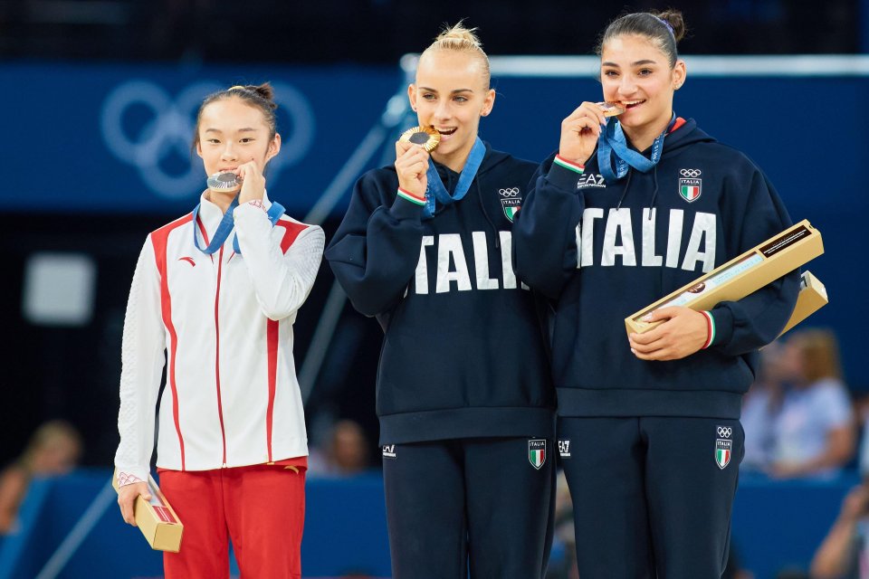 three female athletes wearing italia sweatshirts celebrate with their medals