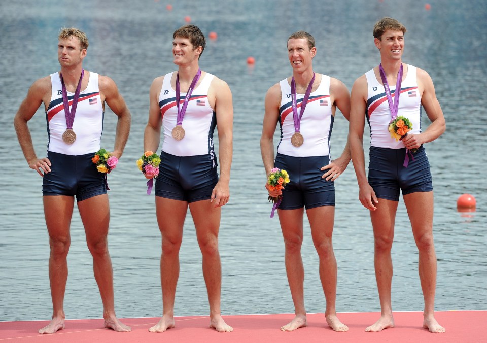 a group of men standing next to each other with medals around their necks