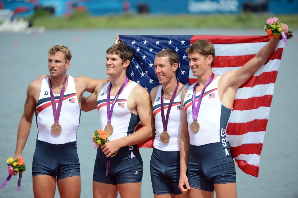 a group of men holding an american flag and medals