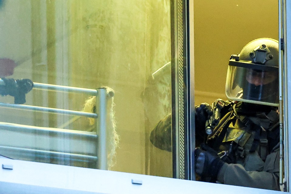 a man wearing a helmet looks out of a window