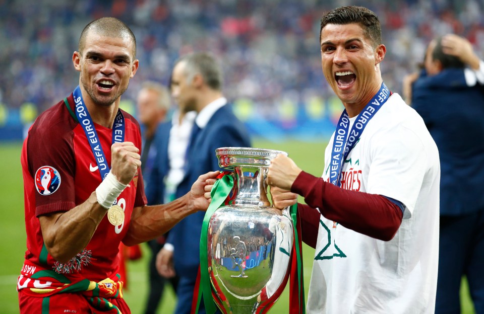 two soccer players holding a trophy that says uefa euro 2016