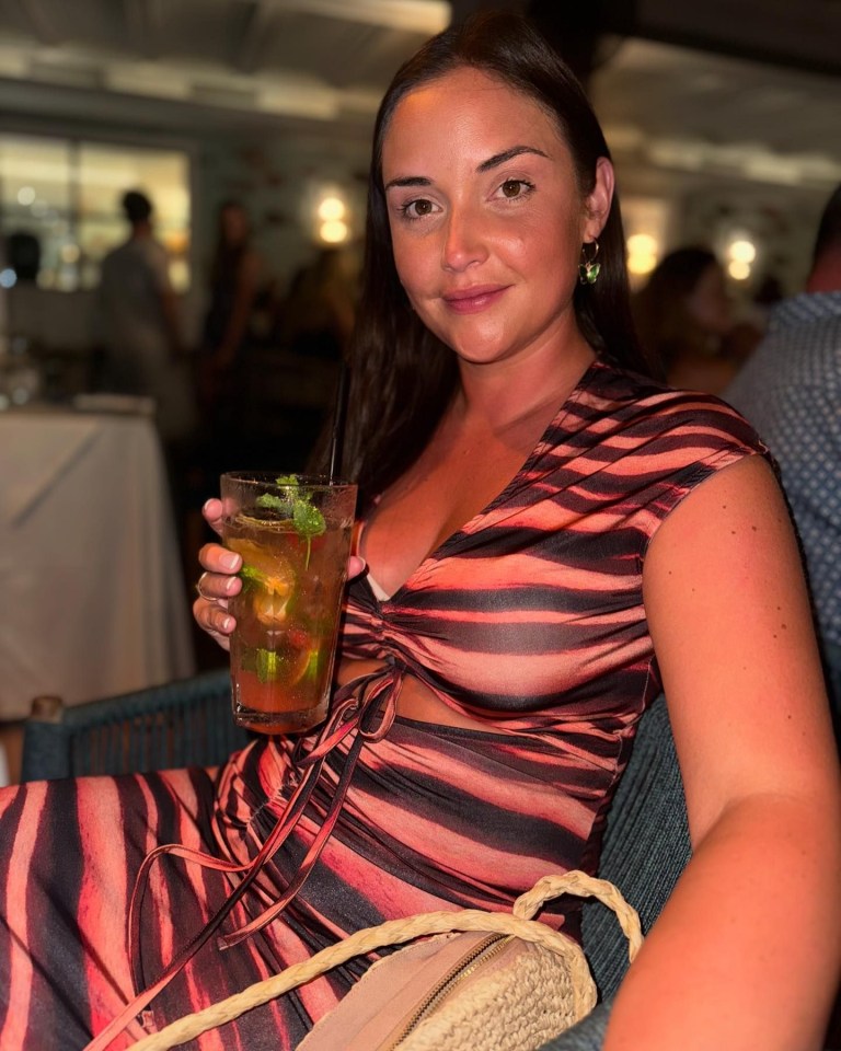 a woman in a zebra print dress is holding a drink with a straw