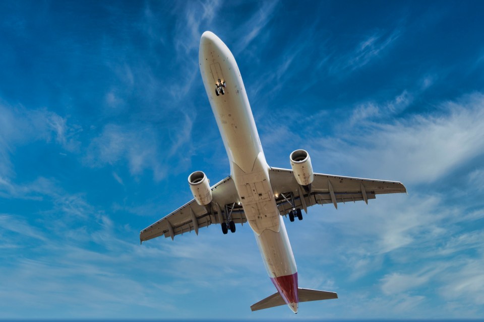 an airplane is flying through a cloudy blue sky