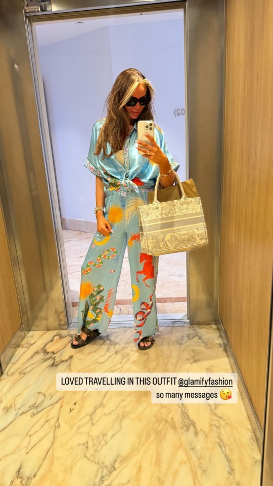 a woman taking a selfie in an elevator with the caption loved travelling in this outfit