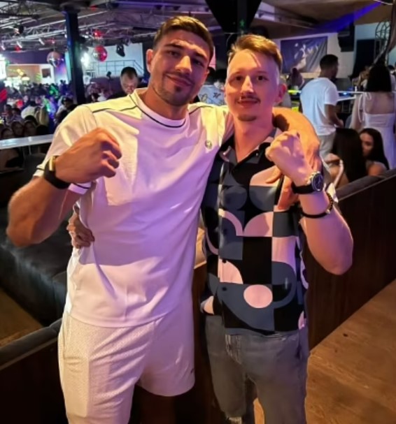 two men are posing for a picture in a club