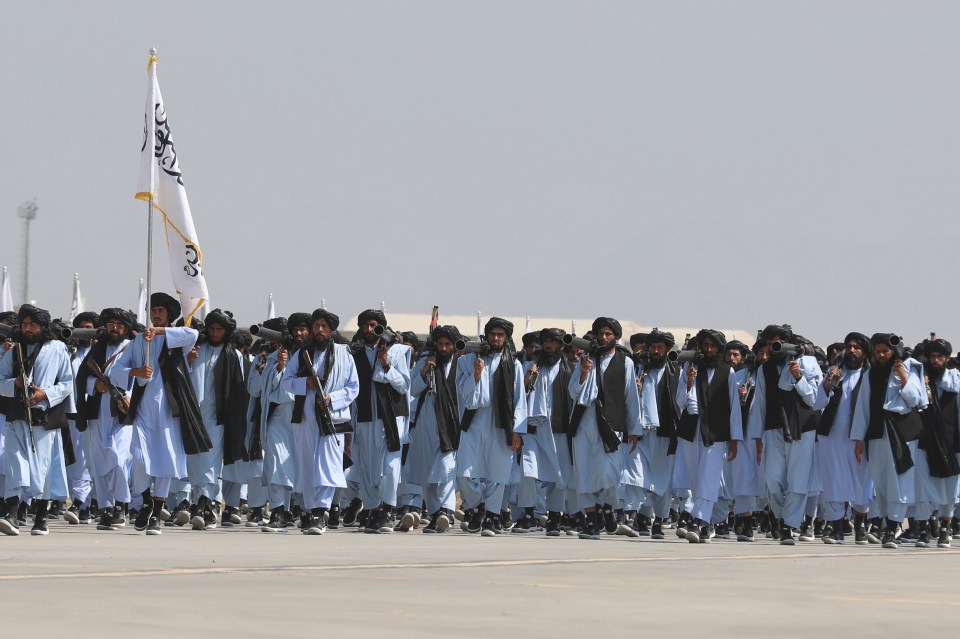 Taliban fighters march during the parade at the former US base