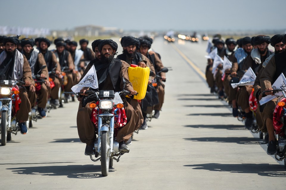 Taliban fighters carry a dummy yellow canister during the parade - intended to contain homemade explosives