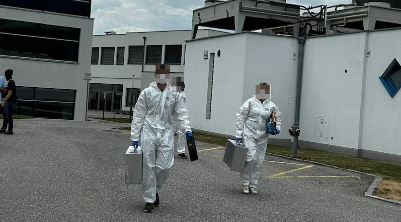 a man and a woman in protective suits are walking down a street