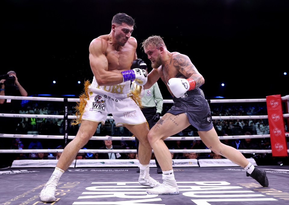 two boxers in a ring with the word fury on their shorts