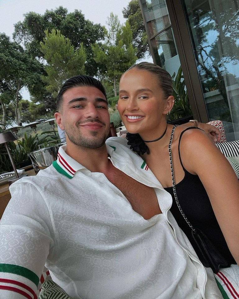 a man and a woman are posing for a picture with trees in the background