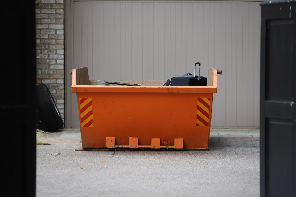 an orange dumpster with yellow and red stripes on the side