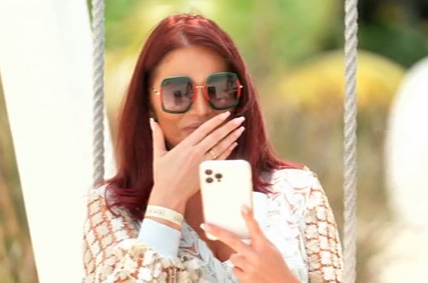 a woman wearing sunglasses is looking at her phone