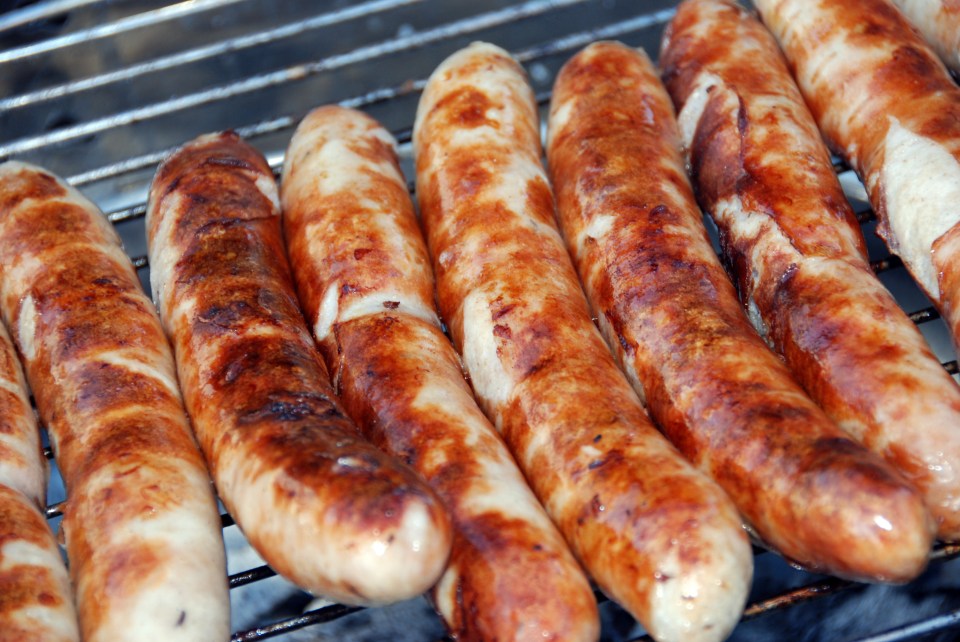 a bunch of sausages are cooking on a grill