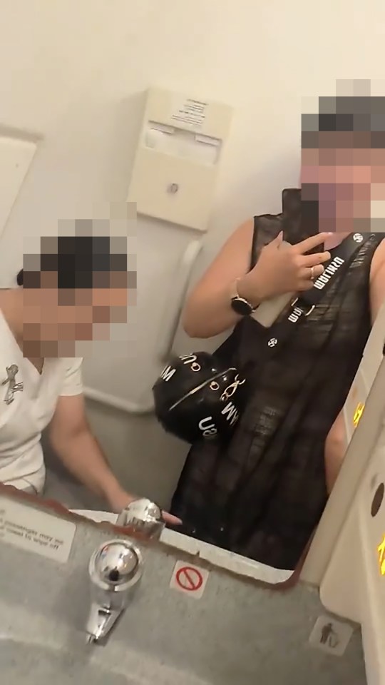 a woman taking a picture of herself in a bathroom mirror