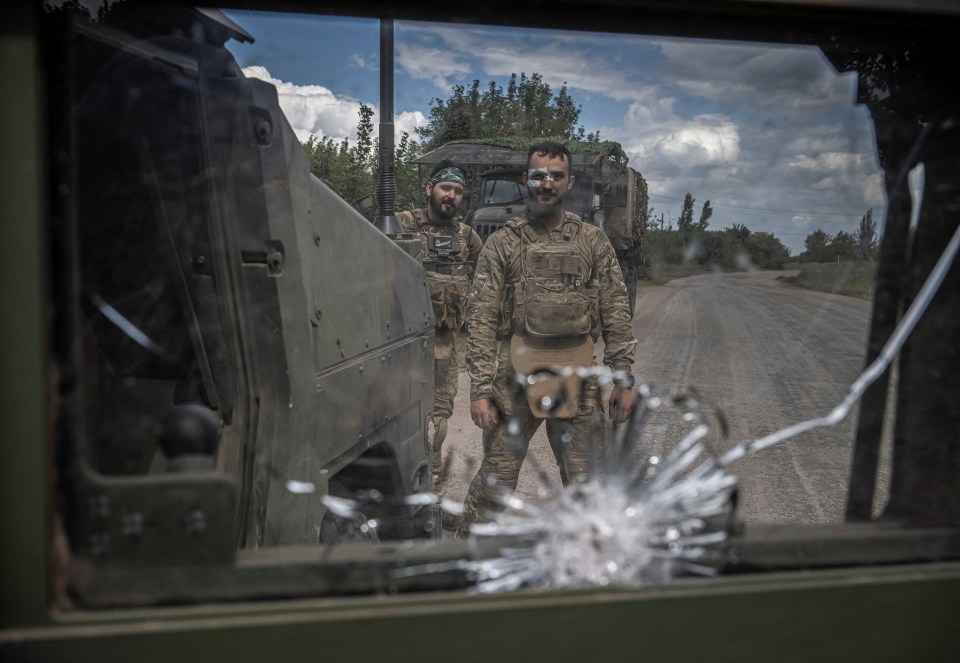 Ukrainian servicemen repair a military vehicle