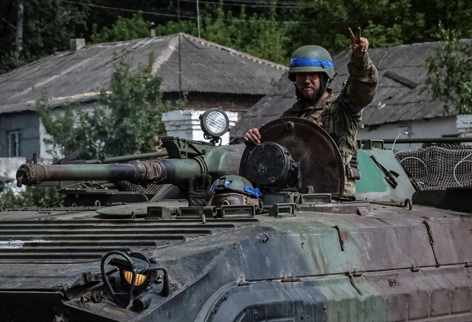 A Ukrainian soldier holds up the peace sign as he goes into battle