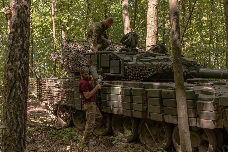 Ukrainian troops unload shells from a Soviet-made T-72 tank in Sumy