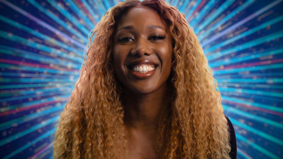 a woman with curly hair is smiling in front of a blue background