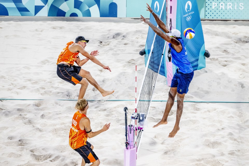 two volleyball players are playing in front of a paris sign