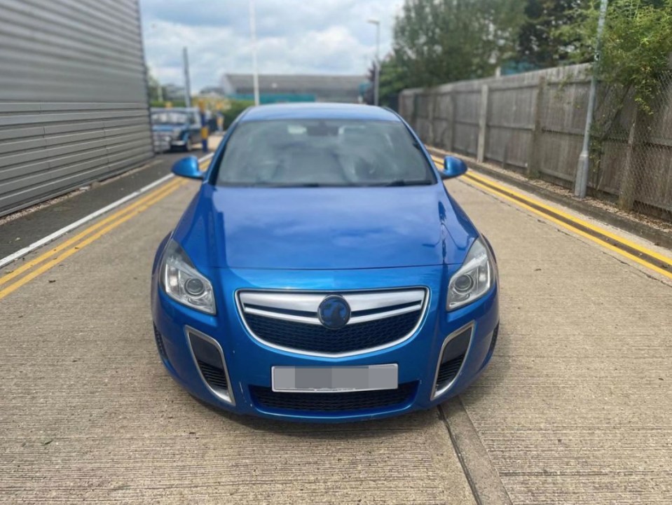 a blue car is parked on the side of the road