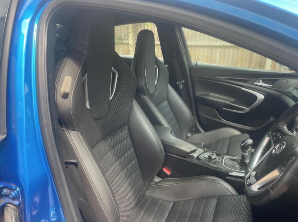 a blue car with black seats that say recaro on them