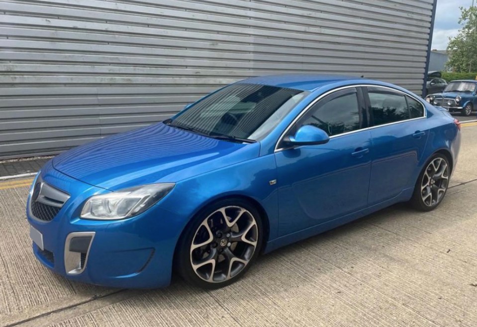 a blue car is parked in front of a building