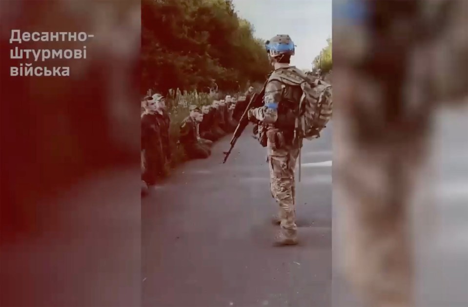 a soldier with a backpack stands in front of a group of soldiers