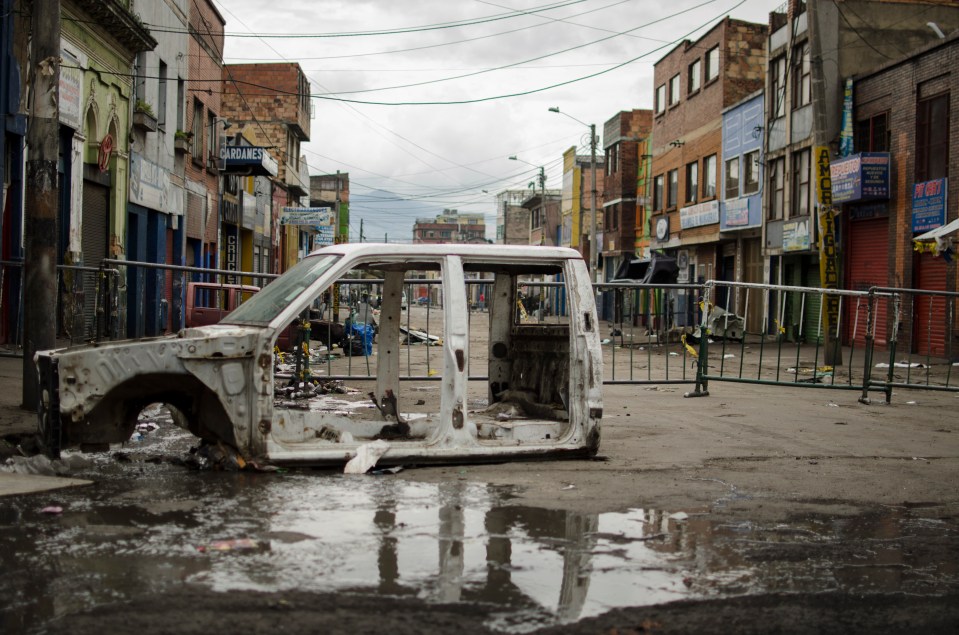 a white truck is sitting in a puddle in front of a building that says ' alquiler ' on it