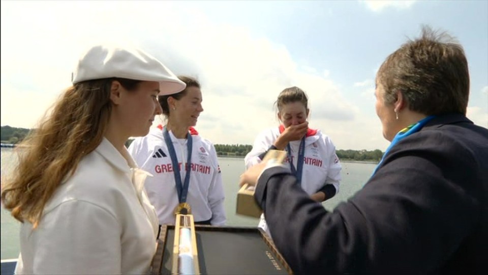 Emily Craig cups her mouth in shock at the sight of her Olympic gold