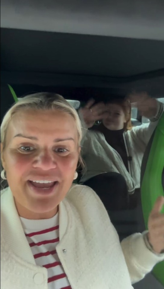 a woman is sitting in the back seat of a car with two children .