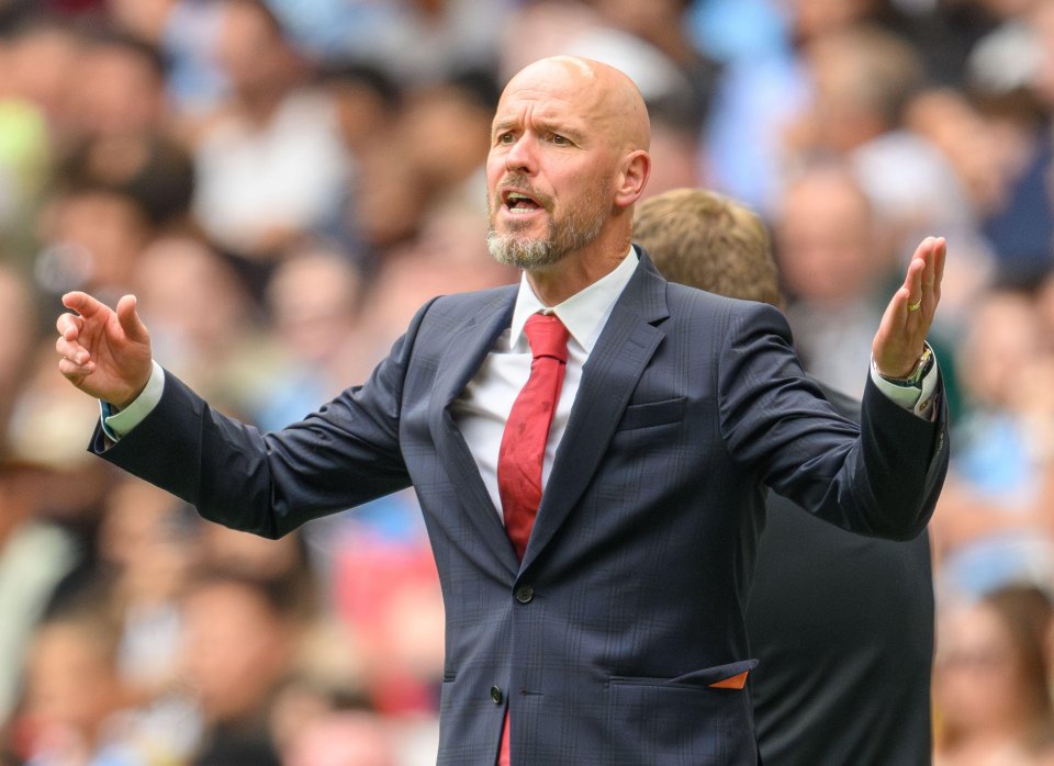 a bald man in a suit and tie stands in front of a crowd